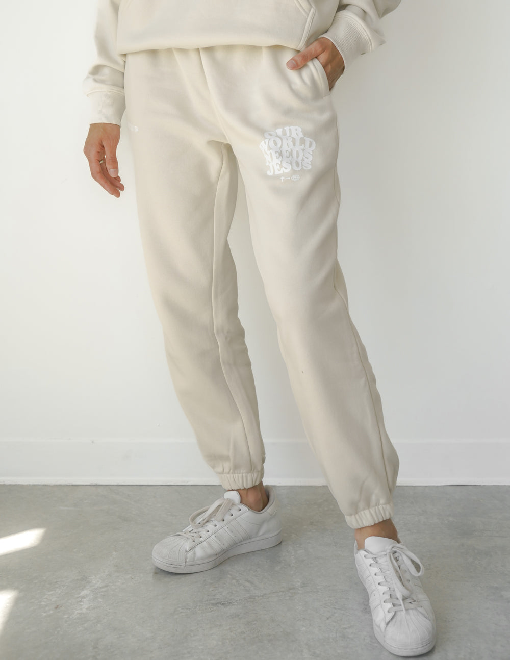Our World Needs Jesus Beige Unisex Sweatpants